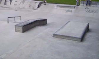 Skatepark showing a grindrail and a half-pipe